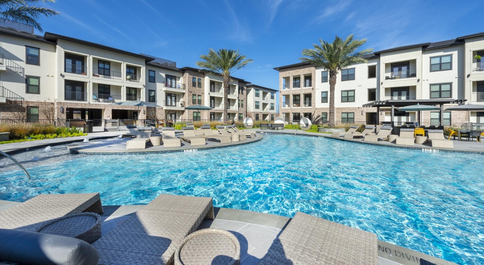 Relax and unwind poolside a pool with chairs around it