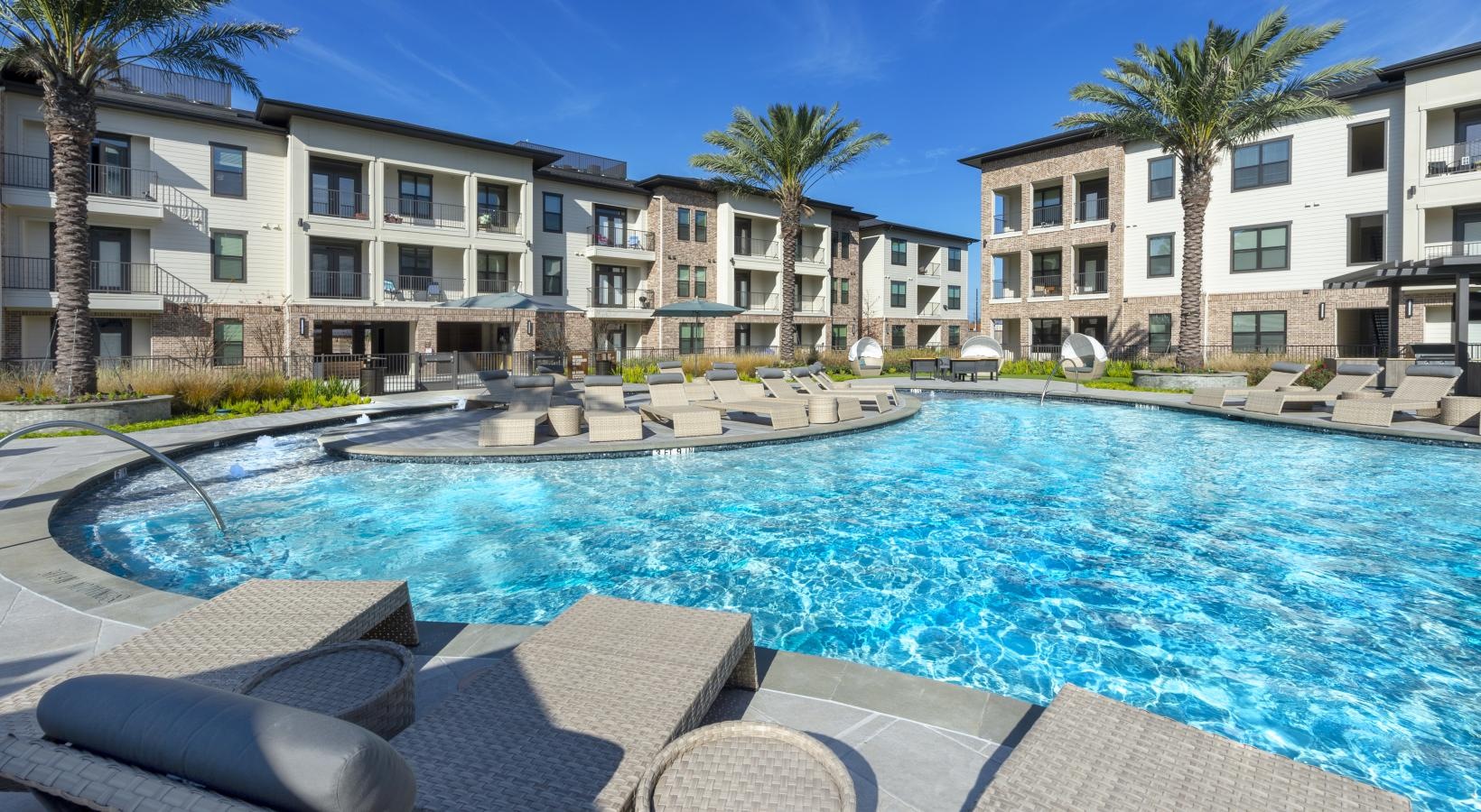 Resort-style swimming pool a pool with chairs around it