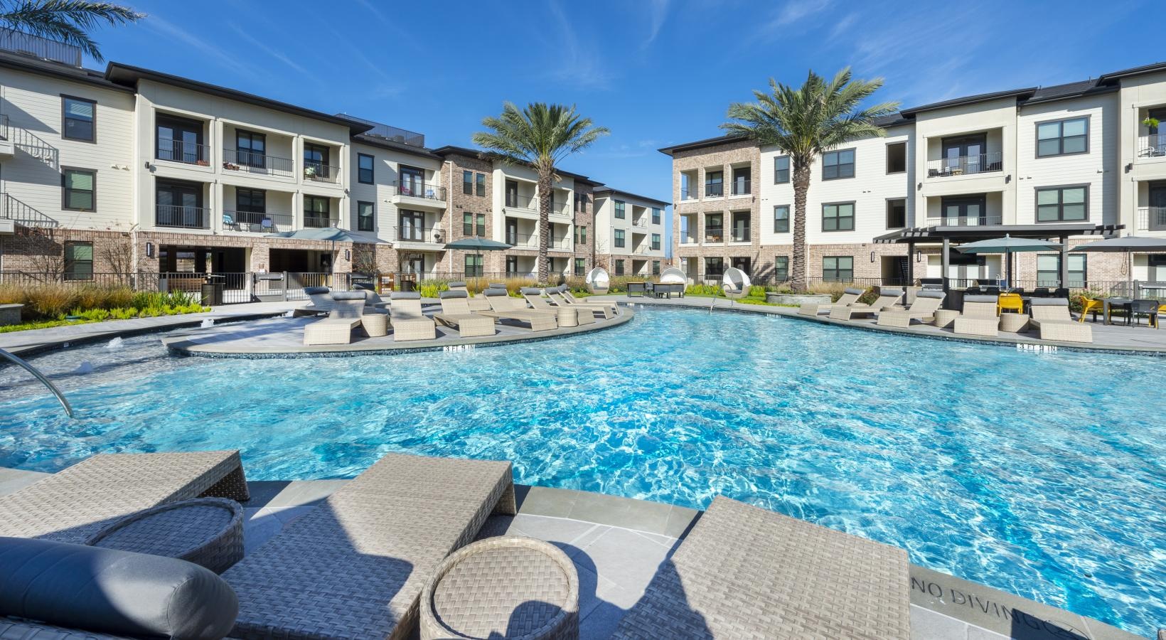 Relax and unwind poolside a pool with chairs around it