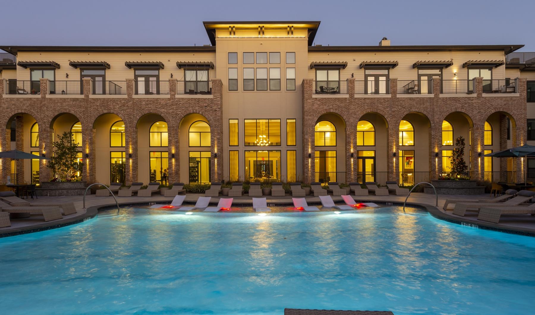 a large building with a pool in front of it