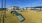 a grassy field with buildings in the background